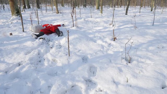 Drunk Santa sleeps on snow in the forest.