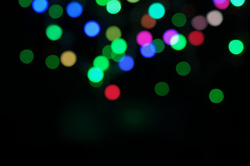 Fototapeta na wymiar Blurred bokeh defocused festive lights. abstract background on black