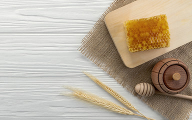Fototapeta na wymiar Top view of honey comb and wooden jar and dipper