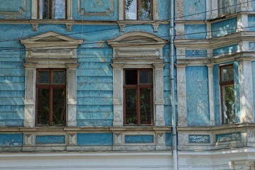 Fototapeta na wymiar two old brown windows on a blue concrete wall