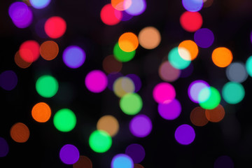 Blurred vibrant bokeh circles abstract background on black