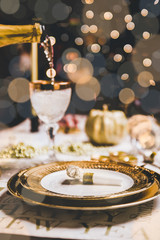 New year table setting with exclusive and luxury golden cutlery, over a tabletop with celebrations world " new year" against a background with great light and bokeh.