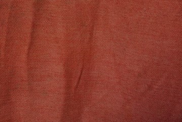 red fabric texture from a piece of crumpled matter on clothes