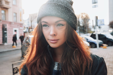 Large portrait of a girl in a hat on the street