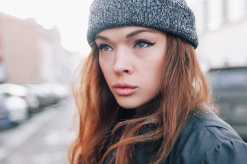 Large portrait of a girl in a hat on the street