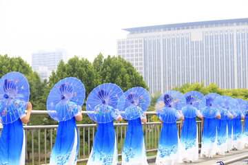 Women in cheongsam are walking，on the bridge