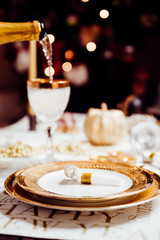 New year table setting with exclusive and luxury golden cutlery, over a tabletop with celebrations world 