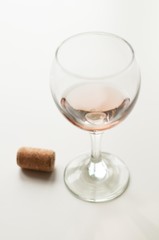 Transparent glass of wine. Pink wine. Festive mood. Alcohol for a group of friends. Delicious drink. Light background. Noble drink. Lavender and rose wine. Wine from lavender