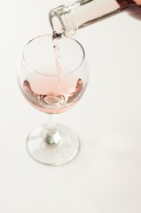 Transparent glass of wine. Pink wine. Festive mood. Alcohol for a group of friends. Delicious drink. Light background. Noble drink. Lavender and rose wine. Wine from lavender