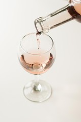 Transparent glass of wine. Pink wine. Festive mood. Alcohol for a group of friends. Delicious drink. Light background. Noble drink. Lavender and rose wine. Wine from lavender