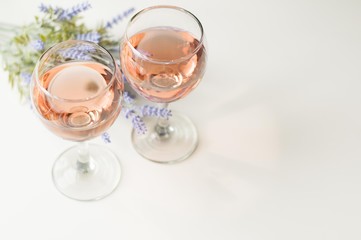 Transparent glass of wine. Pink wine. Festive mood. Alcohol for a group of friends. Delicious drink. Light background. Noble drink. Lavender and rose wine. Wine from lavender