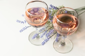 Transparent glass of wine. Pink wine. Festive mood. Alcohol for a group of friends. Delicious drink. Light background. Noble drink. Lavender and rose wine. Wine from lavender