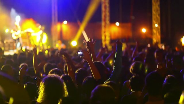 Large crowd of young people dancing at the rock 'n roll concert
