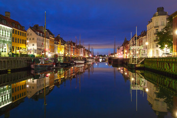 Fototapeta premium Panoramic view of Nyhavn with colorful facades of old houses and old ships in the Old Town of Copenhagen, capital of Denmark.