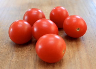 Red ripe cherry tomatoes on wood table close-up