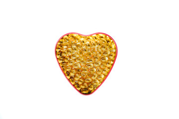 Top view of a heart shaped box with pills inside isolated, white background. Medical concept, care for the heart, eating pills strengthening the heart. Prevention of heart attack, hypertension.