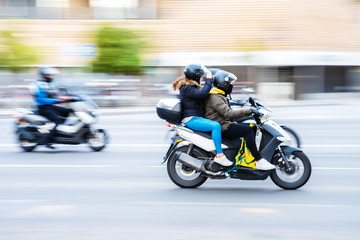 motorcycle rider with pillion in city traffic