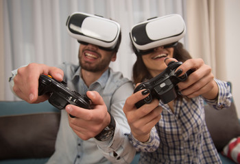 couple playing video games wearing virtual reality glasses.