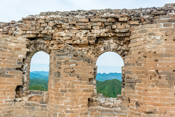 Fototapeta na wymiar A View of The Great Wall of China Looking Through a Brick Window of a Guard House in the Jinshanling Mountains