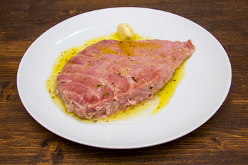 Slice of tuna on plate on a wooden table