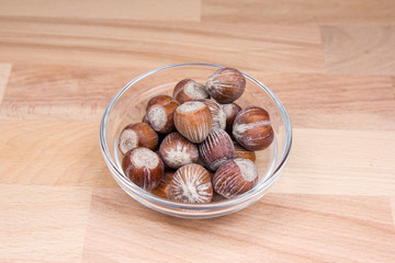 Fototapeta premium Hazelnuts on bowl on a beech wood table