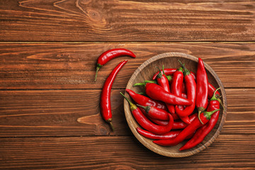 Flat lay composition with fresh chili peppers and space for text on wooden background