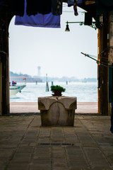 A not touristy spot in Venice, italy. The beauty of this city is also in the hidden spots where architecture is simple. Here a old street with the typical water well and a view to the sea in the back