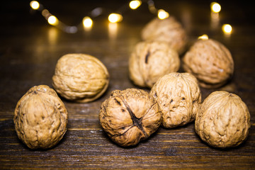Walnuts on a wooden table with blurred lights in the background