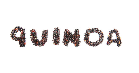 Word QUINOA written with black seeds on white background, top view