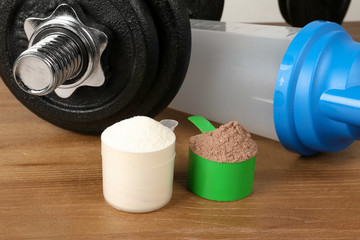 Scoops with protein shake powders on table, closeup