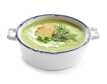 Fresh vegetable detox soup made of green peas with croutons in dish on white background