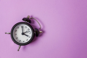 Ringing twin bell vintage classic alarm clock Isolated on purple violet pastel colourful...