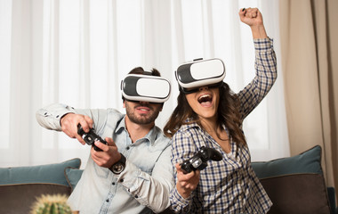 couple playing video games wearing virtual reality glasses.