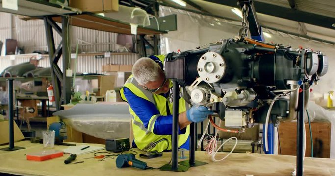 Engineer repairing aircraft engine in hangar 4k