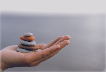 Pile of stacked stones in human hand