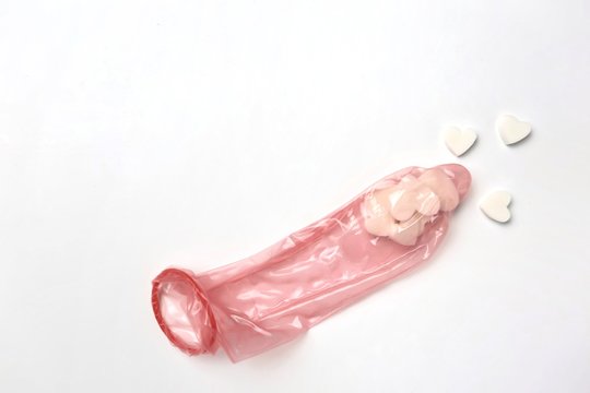 White hearts look like sperm in red 52mm comdom on white background