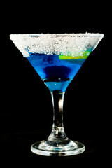 Blue kamikaze cocktail with vodka, lime juice, blue curacao, sugar and lime wedge
