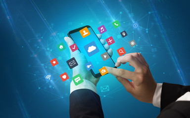 Female hand using smartphone with colorful application icons around