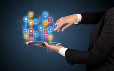Female elegant hand holding tablet with colourful application icons