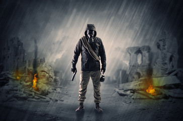 Destroyed place after a catastrophe with man in gas mask and weapon on his hand
