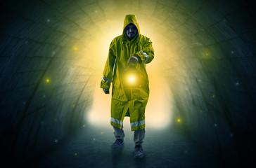 Ugly man in raincoat walking with glowing lantern in a dark tunnel
