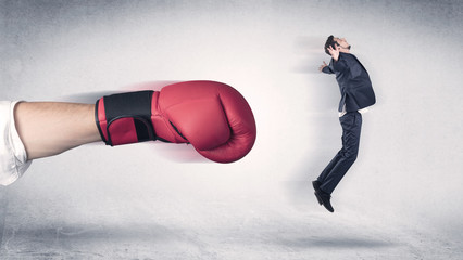 Businessman gets fired from his job by a huge hand in boxing gloves
