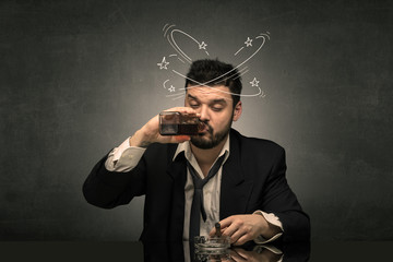 Young drunk man at his office with doodles around
