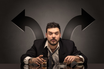 Drunk disappointed man sitting at table with arrows around

