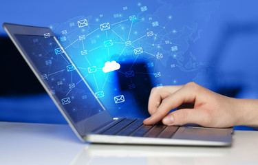 Hand using laptop with cloud computing and online storage concept

