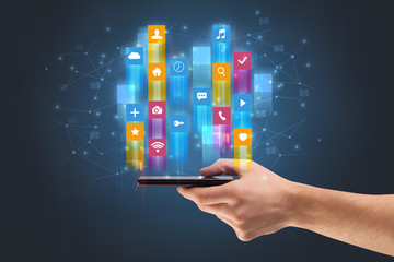 Businessman hand using phone with flying application icons around
