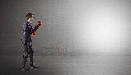 Obraz premium Businessman fighting with boxing gloves in an empty space 