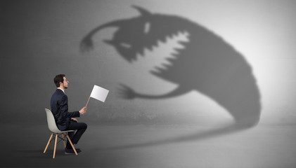 Young businessman staying and  negotiate with a monster shadow
