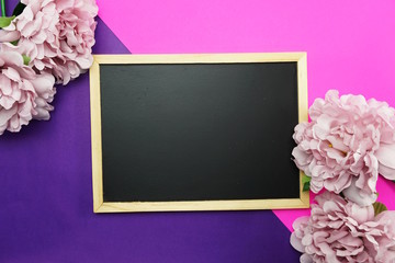 blackboard and bunch of peony flower on pink and purple background flat lay