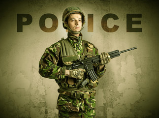 Uniformed armed soldier with damaged wall background
